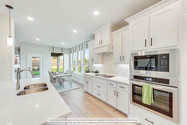 401 Sparrow Dr, Wylie, TX 75098 - kitchen with oven, a sink, built in microwave, black electric cooktop, and light countertops