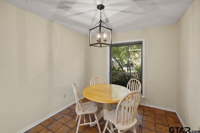 641 Hideaway Ln E, Hideaway, TX 75771 - dining area featuring a chandelier, a textured ceiling, dark tile patterned flooring, and baseboards