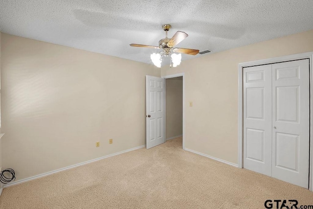 641 Hideaway Ln E, Hideaway, TX 75771 - unfurnished bedroom featuring light carpet, a textured ceiling, a closet, baseboards, and ceiling fan