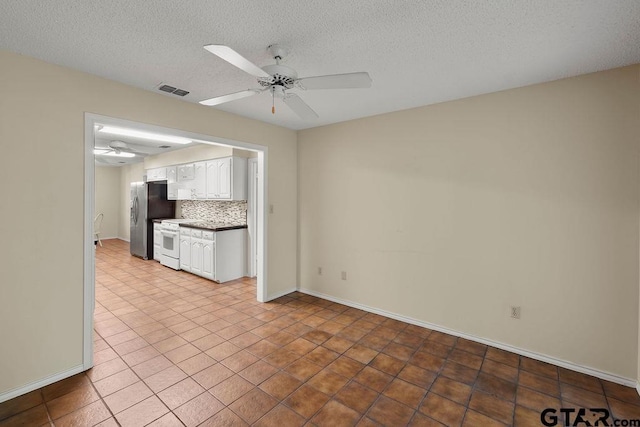 641 Hideaway Ln E, Hideaway, TX 75771 - unfurnished living room with a ceiling fan, a textured ceiling, light tile patterned flooring, and baseboards