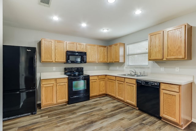 1508 Caymus Ct, Lewisville, TX 75067 - kitchen with black appliances, a sink, wood finished floors, light countertops, and recessed lighting