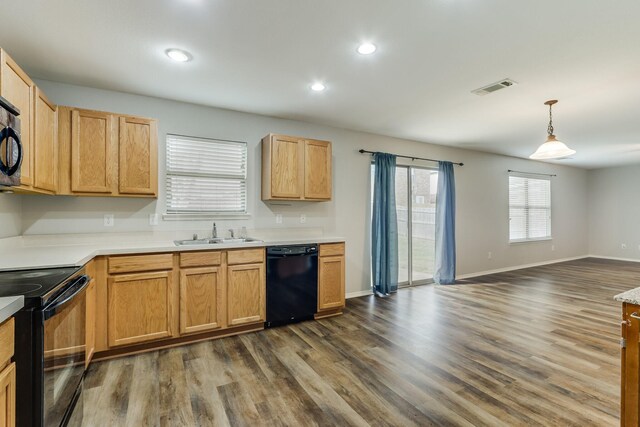 1508 Caymus Ct, Lewisville, TX 75067 - kitchen featuring black appliances, a sink, dark wood-style floors, open floor plan, and light countertops