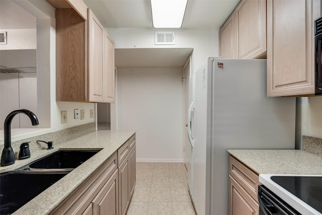 2807 Lineville Dr Unit 104, Farmers Branch, TX 75234 - kitchen featuring a sink, light brown cabinetry, light stone counters, and baseboards