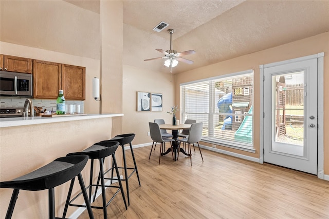 10328 Lone Pine Ln, Fort Worth, TX 76108 - dining area featuring light wood-type flooring, baseboards, a ceiling fan, a textured ceiling, and lofted ceiling