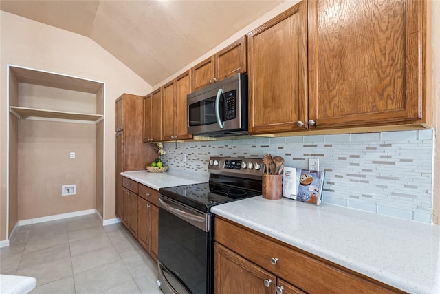 10328 Lone Pine Ln, Fort Worth, TX 76108 - kitchen with stainless steel appliances, brown cabinetry, light countertops, vaulted ceiling, and backsplash