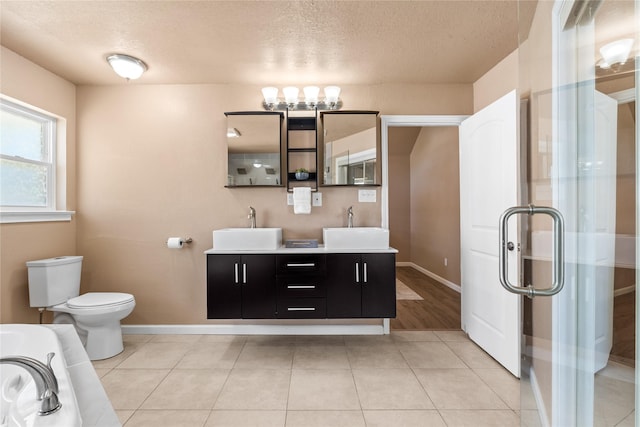 10328 Lone Pine Ln, Fort Worth, TX 76108 - bathroom featuring a textured ceiling, baseboards, double vanity, toilet, and a chandelier