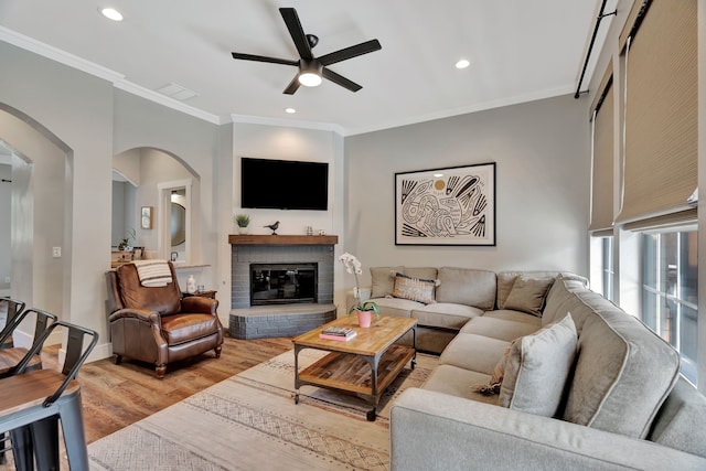 940 Crown Ct, Highland Village, TX 75077 - living room with a ceiling fan, arched walkways, ornamental molding, light wood finished floors, and a fireplace