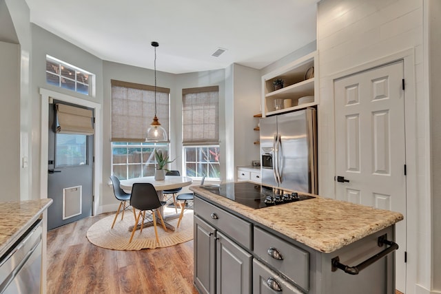940 Crown Ct, Highland Village, TX 75077 - kitchen with appliances with stainless steel finishes, gray cabinetry, wood finished floors, open shelves, and light stone counters