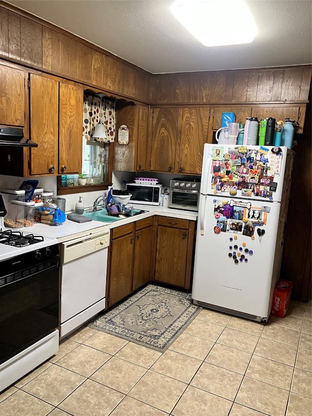 9008 Sara Ln Unit 1, Shreveport, LA 71118 - kitchen with white appliances, light countertops, under cabinet range hood, light tile patterned floors, and a sink