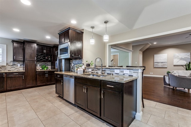 1117 Brandy Sta, Richardson, TX 75080 - kitchen with a sink, appliances with stainless steel finishes, light tile patterned floors, tasteful backsplash, and light stone countertops