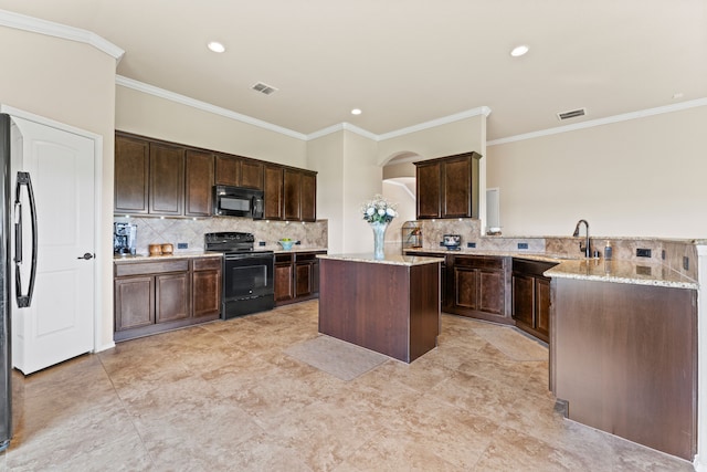 8400 Sioux Trl, Aubrey, TX 76227 - kitchen with black appliances, a center island, crown molding, a peninsula, and dark brown cabinets