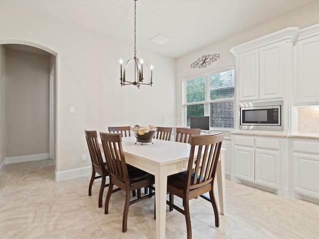 897 Clear Water Dr, Allen, TX 75013 - dining area with arched walkways, a chandelier, and baseboards