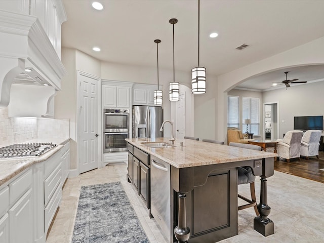 897 Clear Water Dr, Allen, TX 75013 - kitchen with a sink, stainless steel appliances, arched walkways, a ceiling fan, and recessed lighting