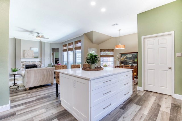 10108 Hunter Run, Frisco, TX 75035 - kitchen featuring ceiling fan, light wood-style floors, white cabinetry, light countertops, and lofted ceiling