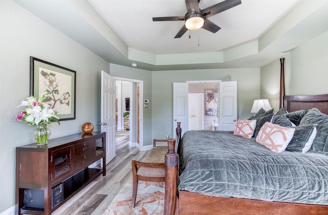10108 Hunter Run, Frisco, TX 75035 - bedroom featuring light wood-style floors, connected bathroom, and a ceiling fan