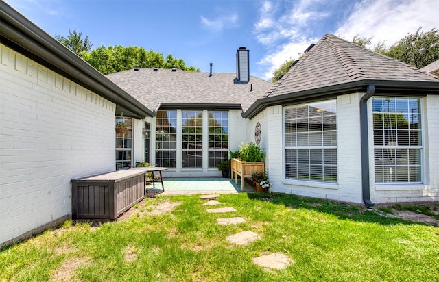 10108 Hunter Run, Frisco, TX 75035 - rear view of property with a chimney, roof with shingles, brick siding, and a yard
