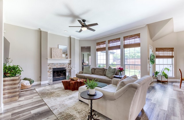 10108 Hunter Run, Frisco, TX 75035 - living area with ceiling fan, wood finished floors, a stone fireplace, and ornamental molding