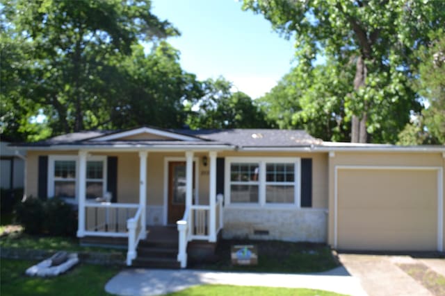 202 Pine St, Arlington, TX 76011 - view of front facade with covered porch, driveway, a garage, stone siding, and a front lawn