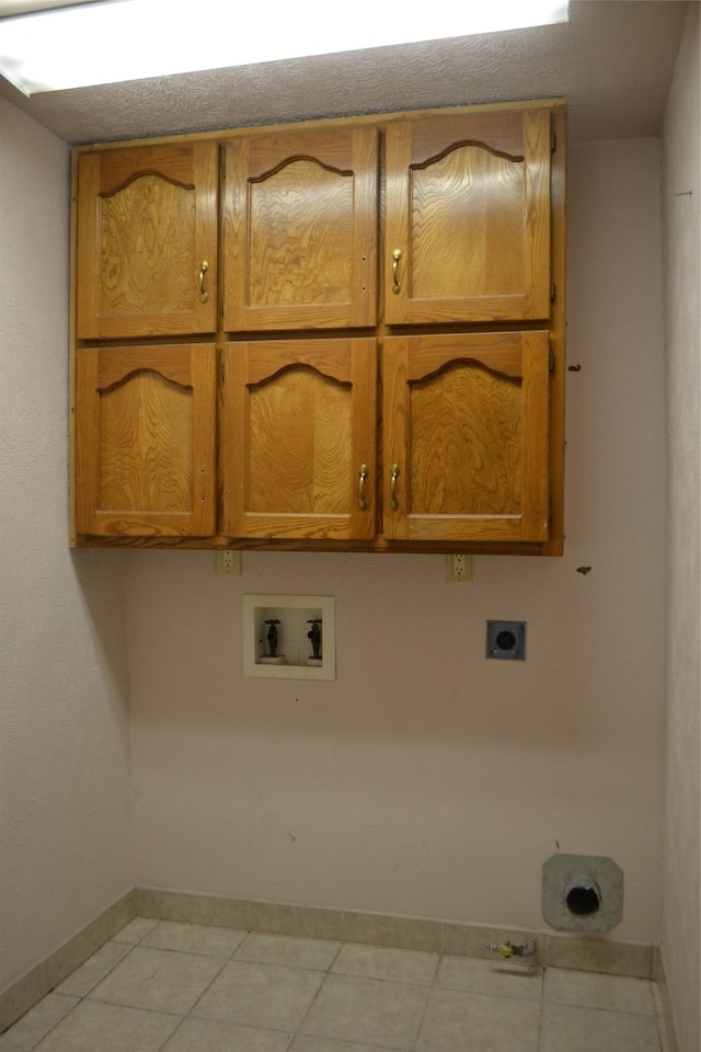 202 Pine St, Arlington, TX 76011 - laundry area with cabinet space, hookup for an electric dryer, hookup for a washing machine, baseboards, and light tile patterned floors
