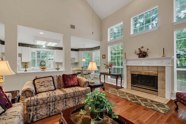 3916 Navajo Ln, Bedford, TX 76021 - living room featuring high vaulted ceiling, wood finished floors, and a tiled fireplace