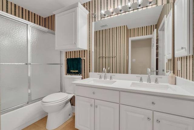 3916 Navajo Ln, Bedford, TX 76021 - full bath with wallpapered walls, toilet, tile patterned floors, double vanity, and enclosed tub / shower combo