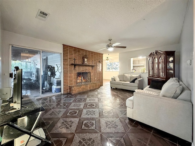 2725 Rustown Dr, Mesquite, TX 75150 - living room featuring ceiling fan, a fireplace, dark tile patterned floors, and a textured ceiling