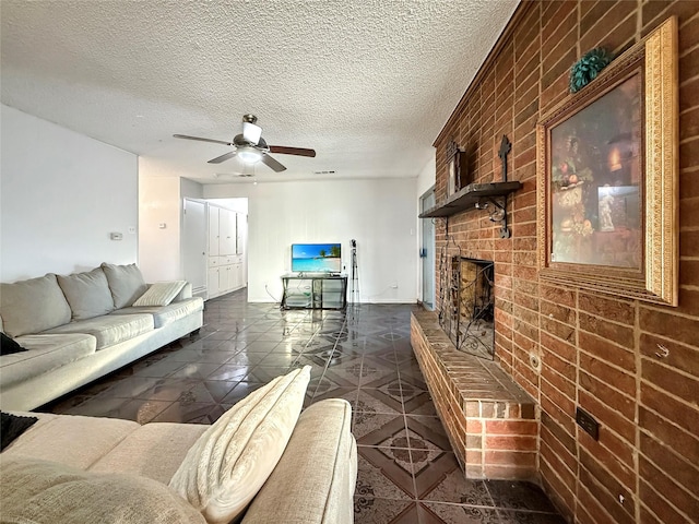 2725 Rustown Dr, Mesquite, TX 75150 - living area with a ceiling fan, a fireplace, brick wall, dark tile patterned flooring, and a textured ceiling