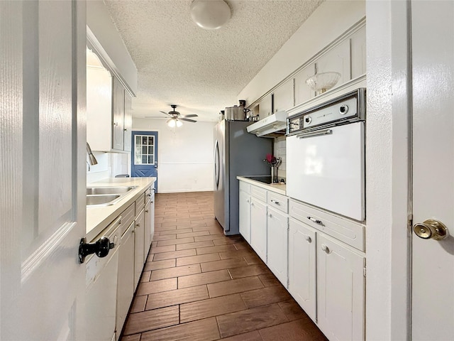2725 Rustown Dr, Mesquite, TX 75150 - kitchen with white appliances, under cabinet range hood, a sink, light countertops, and a ceiling fan