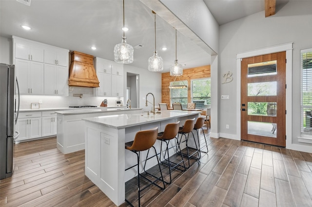 304 Red Roan Rdg, Weatherford, TX 76087 - kitchen with premium range hood, a center island with sink, freestanding refrigerator, recessed lighting, and dark wood-style flooring