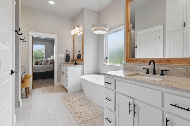 304 Red Roan Rdg, Weatherford, TX 76087 - ensuite bathroom featuring a soaking tub, recessed lighting, two vanities, and tile patterned flooring