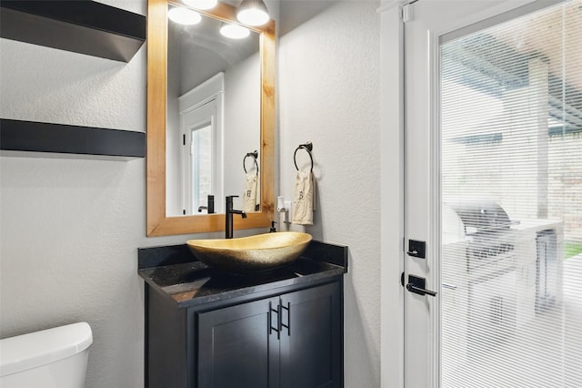 304 Red Roan Rdg, Weatherford, TX 76087 - bathroom featuring a textured wall, toilet, vanity, and healthy amount of natural light