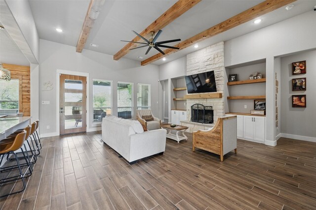 304 Red Roan Rdg, Weatherford, TX 76087 - living room with ceiling fan, beamed ceiling, baseboards, a stone fireplace, and dark wood-style flooring