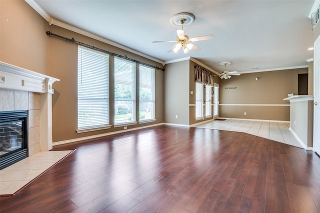 6506 Parkside Dr, Arlington, TX 76001 - unfurnished living room featuring a tiled fireplace, ceiling fan, wood finished floors, and crown molding