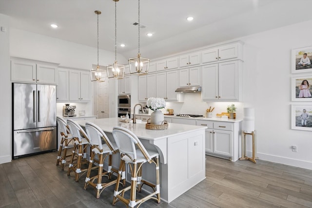 1809 Lithgow Rd, Celina, TX 75009 - kitchen with appliances with stainless steel finishes, light countertops, dark wood finished floors, an island with sink, and white cabinetry