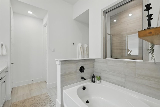 1809 Lithgow Rd, Celina, TX 75009 - bathroom featuring a garden tub, vanity, recessed lighting, and baseboards