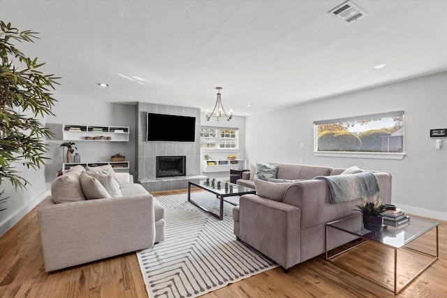 1705 Provincetown Ln, Richardson, TX 75080 - living area featuring a tiled fireplace, wood finished floors, baseboards, a chandelier, and recessed lighting
