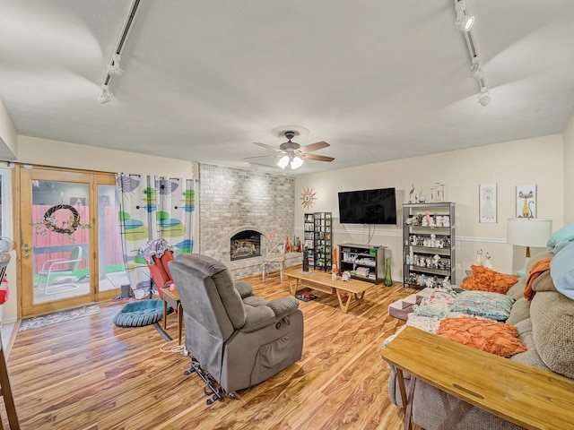 1824 Castille Dr, Carrollton, TX 75007 - living room featuring track lighting, light wood-style floors, a ceiling fan, and a fireplace