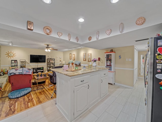 1824 Castille Dr, Carrollton, TX 75007 - kitchen featuring freestanding refrigerator, light tile patterned flooring, a ceiling fan, white cabinetry, and open floor plan