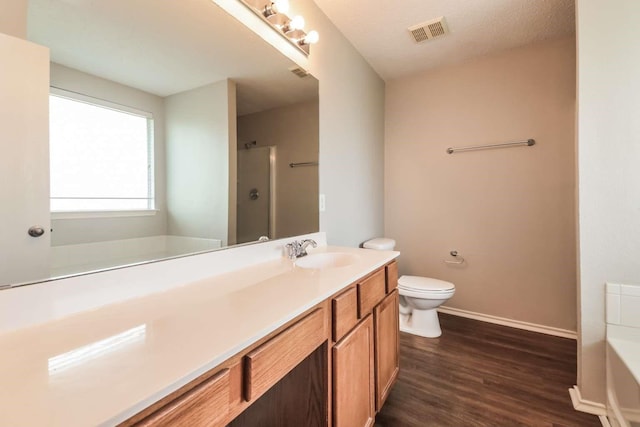 532 Chestnut Trl, Forney, TX 75126 - bathroom featuring a tub to relax in, baseboards, wood finished floors, toilet, and vanity
