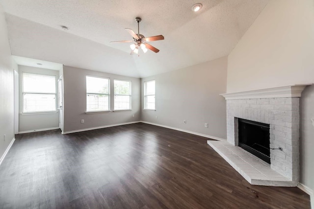532 Chestnut Trl, Forney, TX 75126 - unfurnished living room with ceiling fan, vaulted ceiling, a brick fireplace, dark wood-style floors, and a textured ceiling
