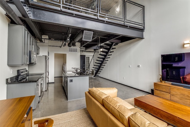 3110 Thomas Ave Unit 535, Dallas, TX 75204 - kitchen with dark countertops, appliances with stainless steel finishes, concrete floors, a sink, and open floor plan