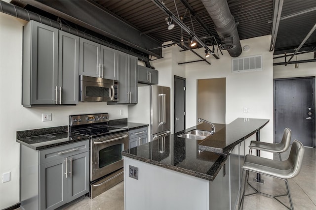 3110 Thomas Ave Unit 535, Dallas, TX 75204 - kitchen with stainless steel appliances, a sink, gray cabinetry, and dark stone counters