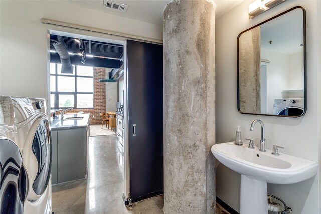 3110 Thomas Ave Unit 535, Dallas, TX 75204 - bathroom featuring finished concrete flooring, a sink, and separate washer and dryer