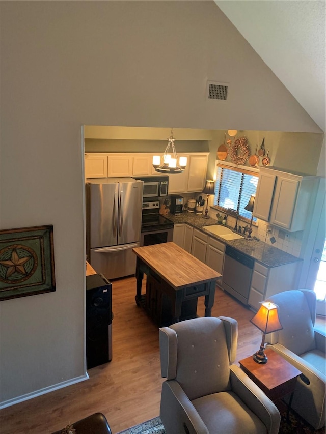 151 Summer Place Cir, Pottsboro, TX 75076 - kitchen with stainless steel appliances, white cabinetry, light wood-style floors, a sink, and a chandelier