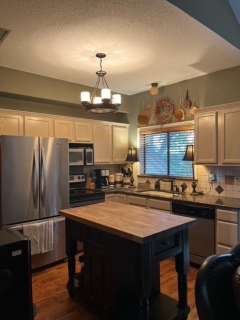 151 Summer Place Cir, Pottsboro, TX 75076 - kitchen with butcher block counters, stainless steel appliances, a sink, decorative backsplash, and a textured ceiling