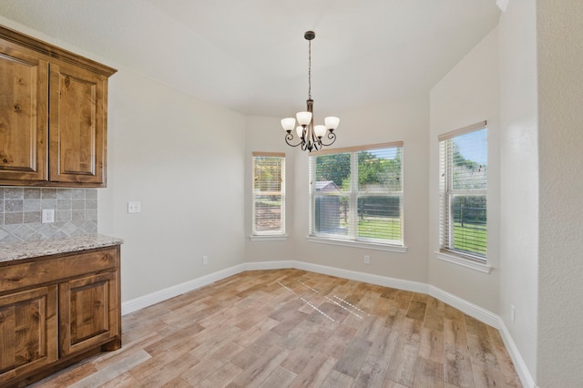 2304 Forest Hill Ln, Granbury, TX 76048 - unfurnished dining area with light wood-style flooring, a chandelier, and baseboards