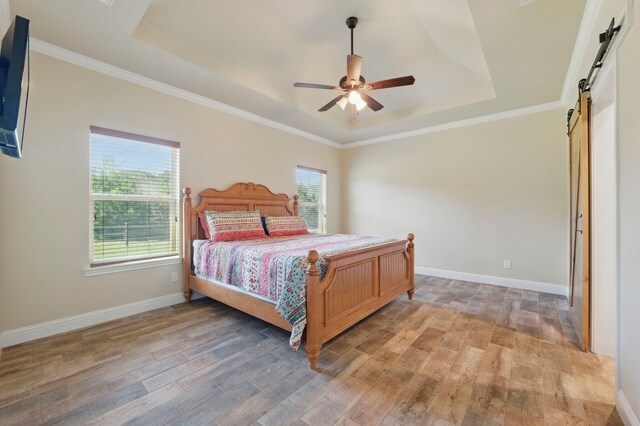 2304 Forest Hill Ln, Granbury, TX 76048 - bedroom with a barn door, a raised ceiling, light wood-style floors, baseboards, and crown molding