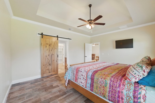 2304 Forest Hill Ln, Granbury, TX 76048 - bedroom featuring a tray ceiling, a barn door, wood finished floors, baseboards, and ornamental molding