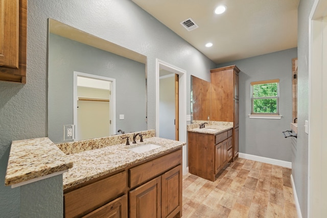 2304 Forest Hill Ln, Granbury, TX 76048 - bathroom featuring wood finished floors, two vanities, recessed lighting, and baseboards