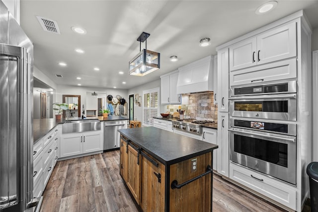 3280 Shady Grove Rd, Midlothian, TX 76065 - kitchen with appliances with stainless steel finishes, a sink, dark countertops, custom exhaust hood, and dark wood finished floors